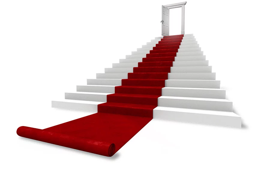 An image of red carpet leading up stairs to an open door
