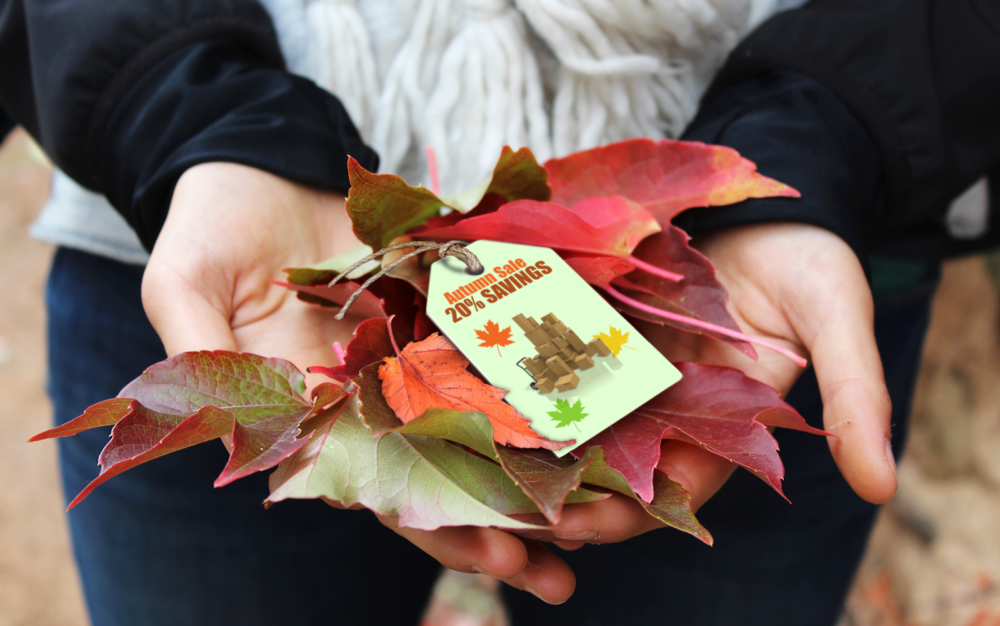 Photograph of hands holding fall leaves and a tag depicting an autumn sale