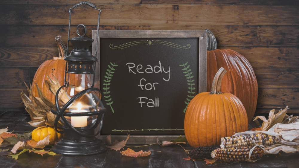 Customized chalkboard surrounded by pumpkins, lantern and wooden back board.